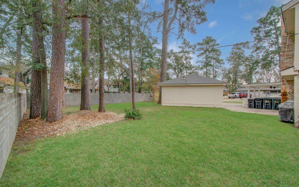 Back yard showing concrete block fence and detached garage.