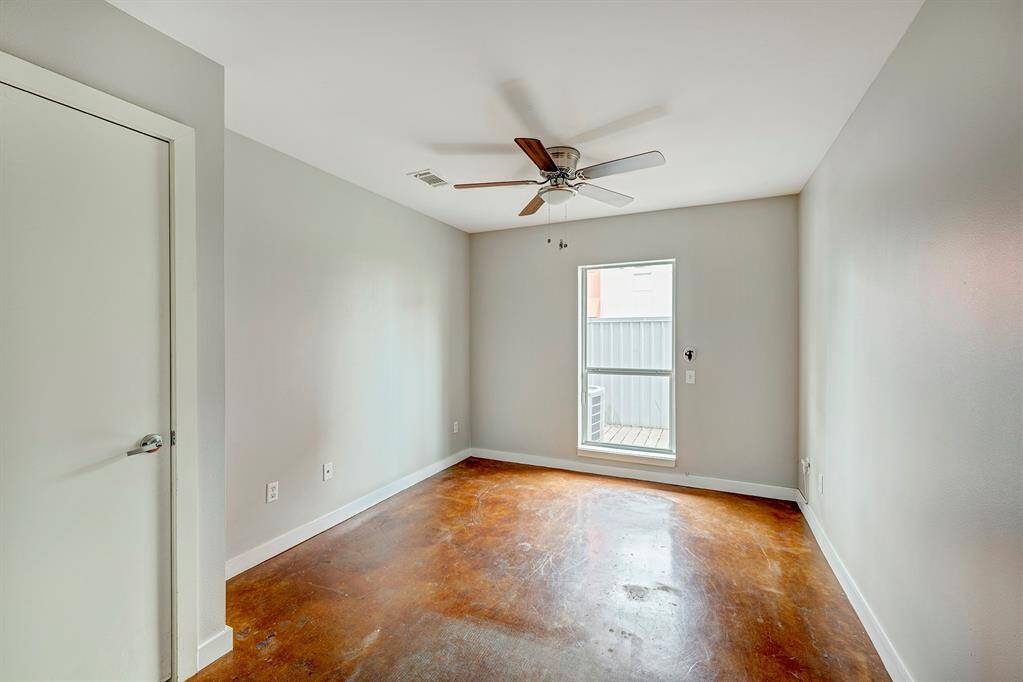 Spacious first floor bedroom with plenty of natural light, nice size closet, ceiling fan and painted cement floors.