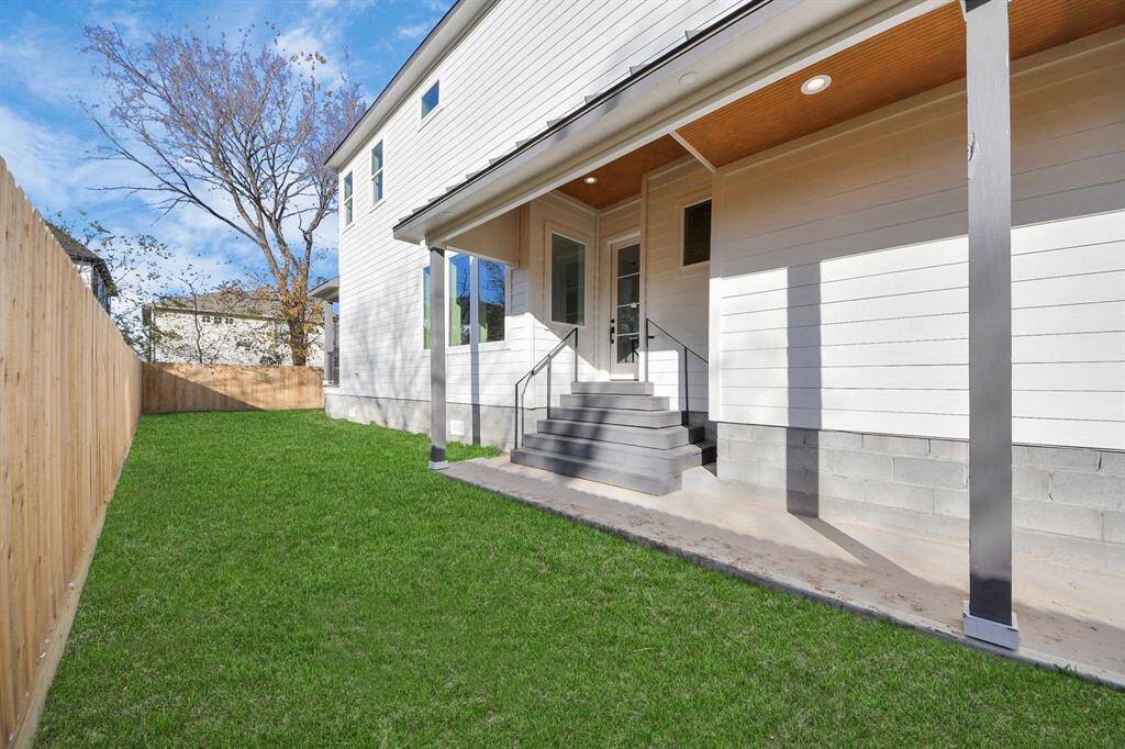A covered walkway leads you to your front door from the driveway, with a metal roofline overhead—an impressive upgrade! The cedar-accented ceiling adds a touch of warmth and style to the entrance.