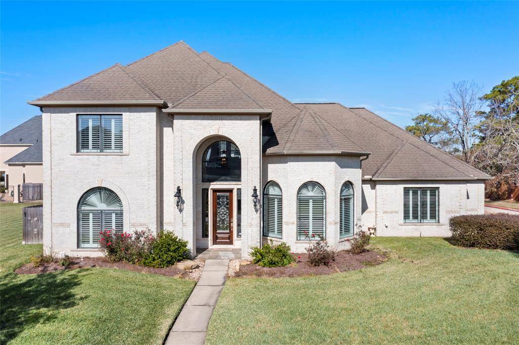 This elegant two-story home features a grand entrance with arched windows, a well-maintained lawn, and classic brickwork. Ideal for families seeking a spacious and stylish living space. Welcome Home!