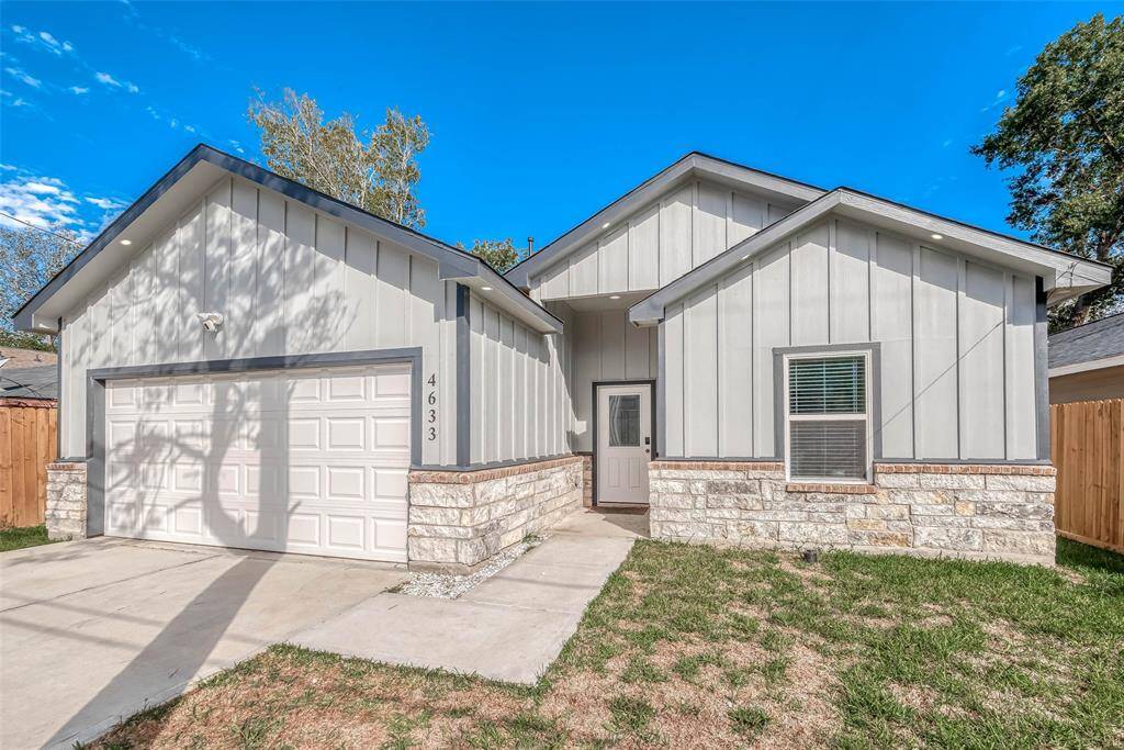 This charming home features a modern exterior with light gray siding and stone accents. It includes a two-car garage, a welcoming front entrance, and a modest yard. Perfect for those seeking a contemporary and low-maintenance property.