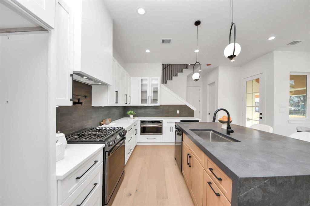 The kitchen features upgraded black stainless steel Frigidaire Gallery appliances, including a built-in microwave with a convenient drop-down handle for easy access. The 5-burner gas range boasts an Air Fry convection oven and an integrated top griddle, expanding your cooking options. For baking enthusiasts, an upgraded steam bake setting and 15 convection cooking modes provide endless possibilities for culinary creativity.