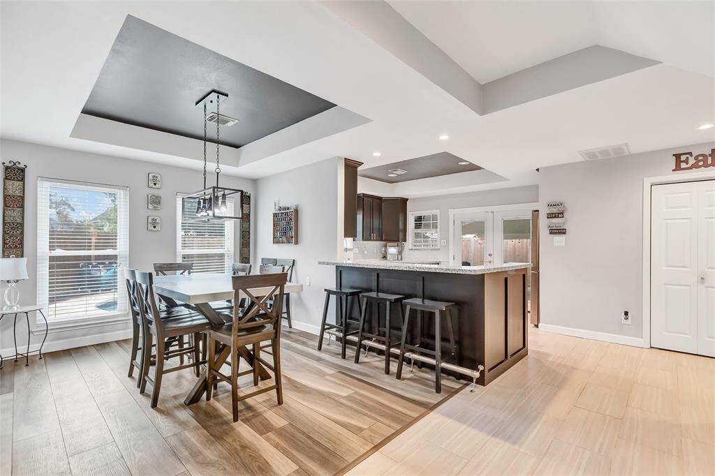 Formal dining room with plenty of space for a large table and an open concept into the kitchen. Check out the recessed ceiling feature and new light fixtures.