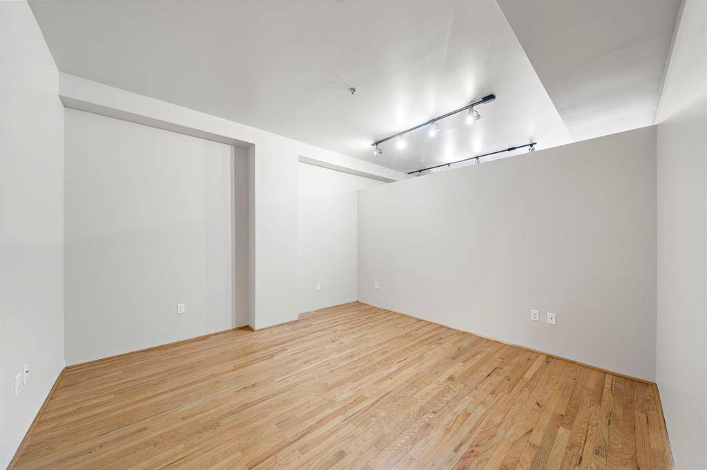 The bedroom has a short wall that allows light from the windows.