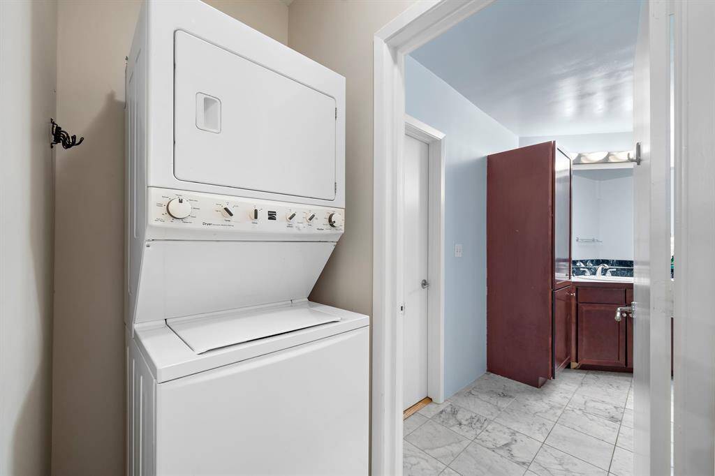 This stacking washer and dryer is across from the closet.