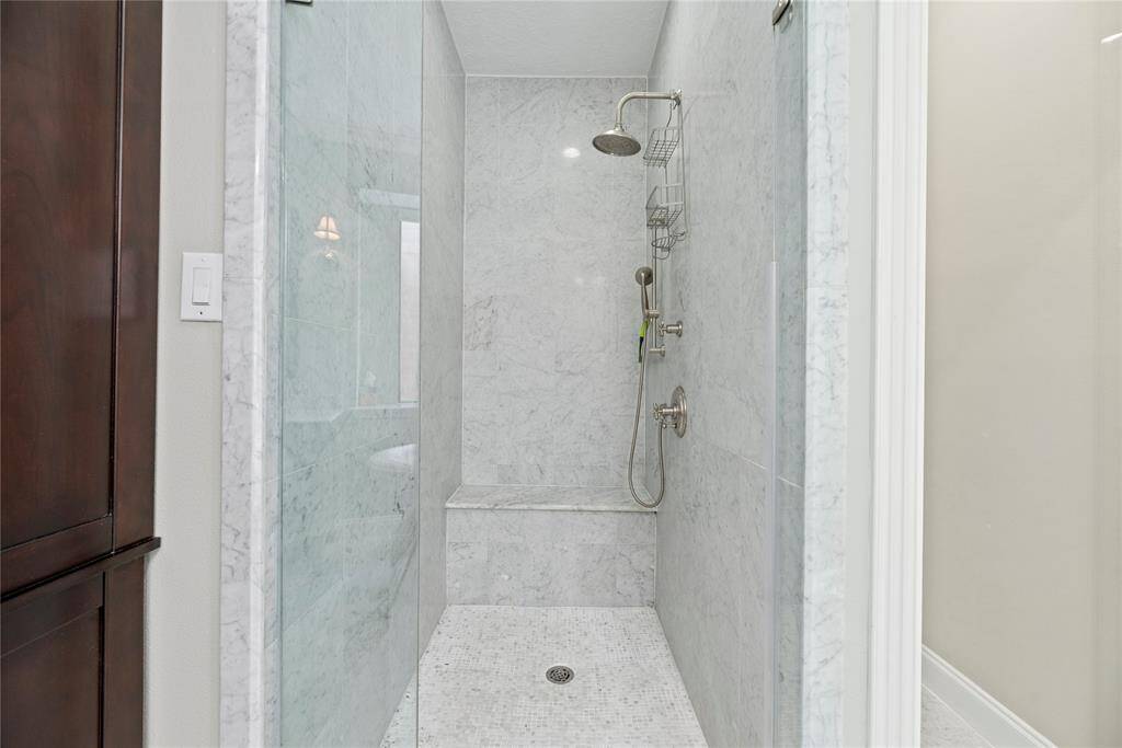 The expansive walk-in shower, with a sleek glass front, offers a luxurious escape for a quick rinse or a refreshing retreat.