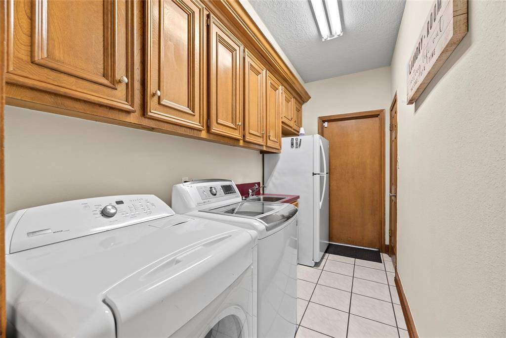 This well-appointed space includes ample storage and efficient organization, making laundry day a breeze while keeping your home tidy and functional, with large sink and room for a fridge!