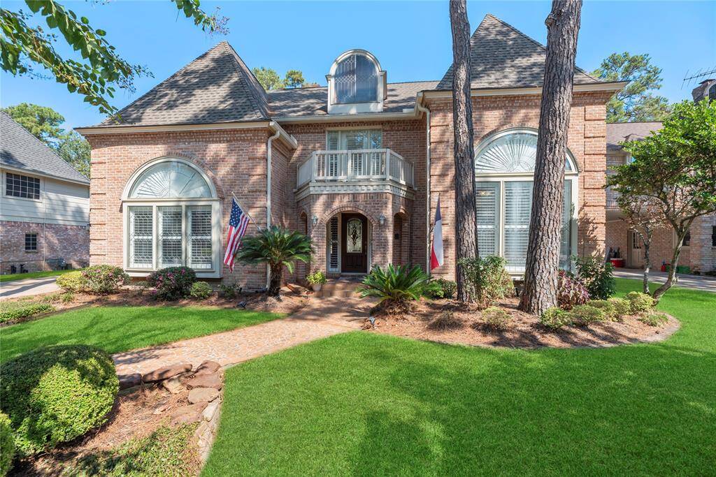 The combination of a professionally landscaped pathway and transom windows framing the front door creates a welcoming and elegant entrance.