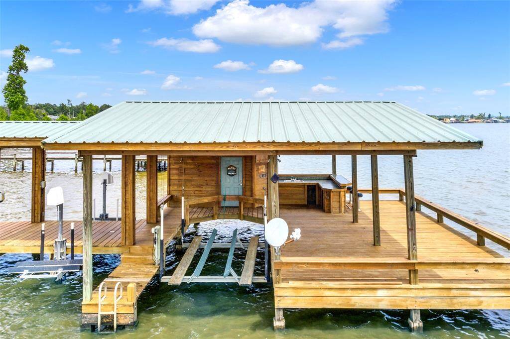 Boathouse includes a boat slip, two jet ski slips, large deck area and outdoor kitchen and bar area with storage.