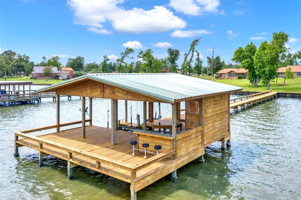 Boathouse includes a boat slip, two jet ski slips, large deck area and outdoor kitchen and bar area with storage.