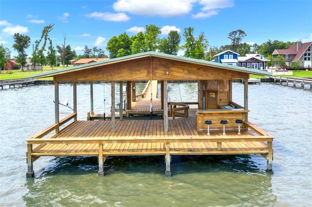 Boathouse includes a boat slip, two jet ski slips, large deck area and outdoor kitchen and bar area with storage.