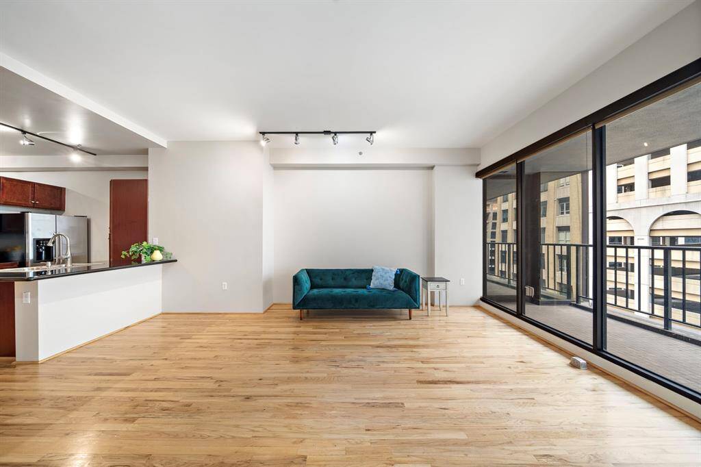 Track lighting illuminates the walls throughout the space. There is room for bar stools around the island.