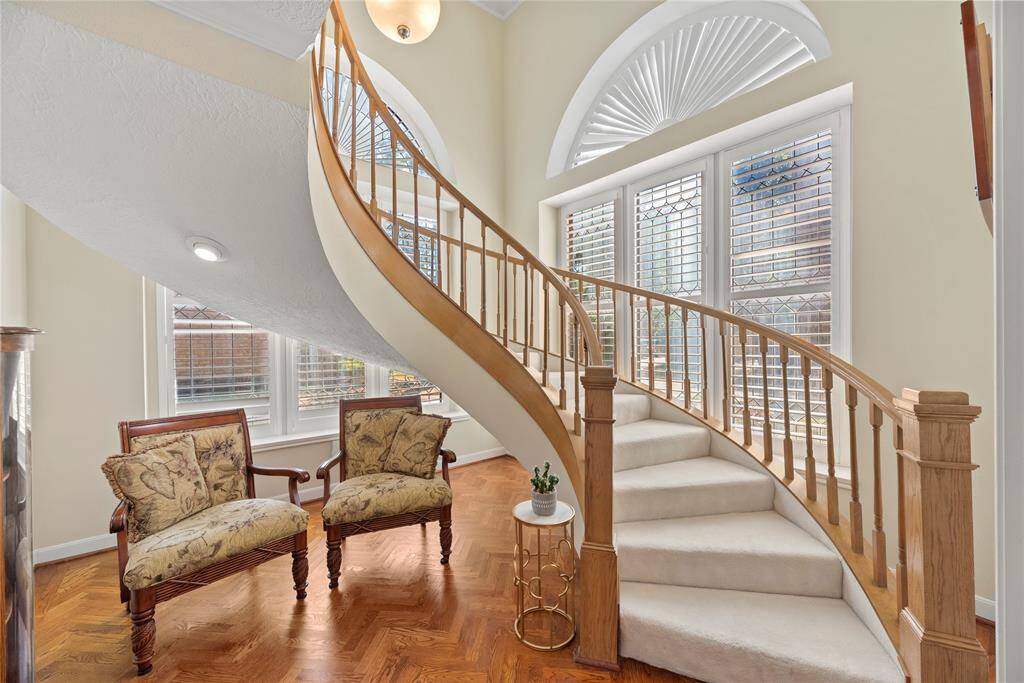 To the right of the entry is your sweeping staircase. The combination of beautiful ceiling lines and wood flooring sets a stunning backdrop for this space, adding warmth, texture, and architectural interest.