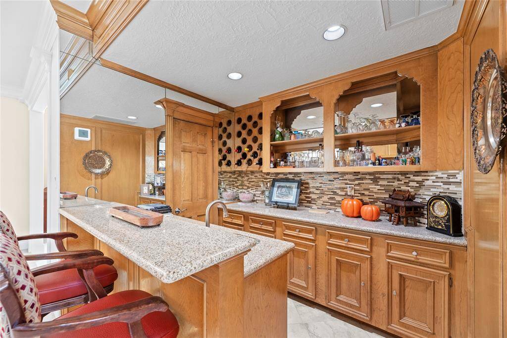 This exquisite built-in wet bar is a true centerpiece for elegant entertaining, seamlessly blending style and functionality. Crafted with the finest materials, it features a sleek countertop, custom cabinetry, and high-end fixtures that invite sophistication.