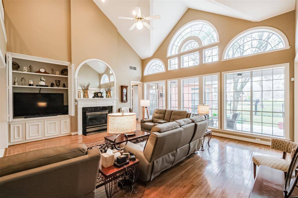 STUNNING FAMILY ROOM WITH VAULTED CEILINGS, GLEAMING WOOD FLOORS, AND A COZY FIREPLACE—PERFECT FOR RELAXING OR ENTERTAINING.