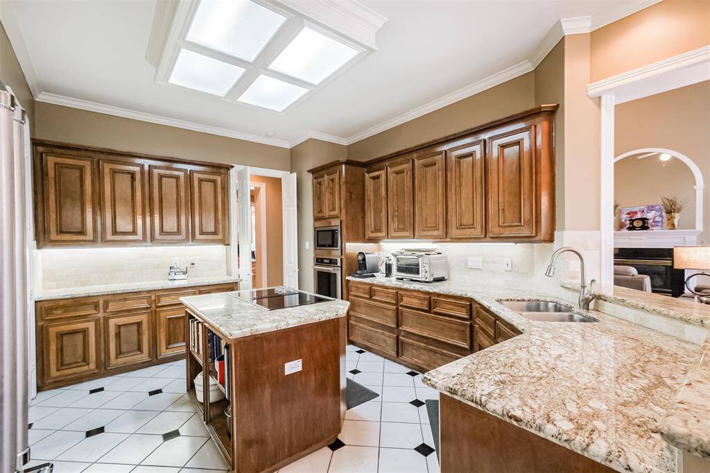 ELEVATE YOUR STORAGE GAME WITH THIS BEAUTIFUL BUTLER'S PANTRY FEATURING GRANITE COUNTERS AND GLASS-FRONT CABINETS.