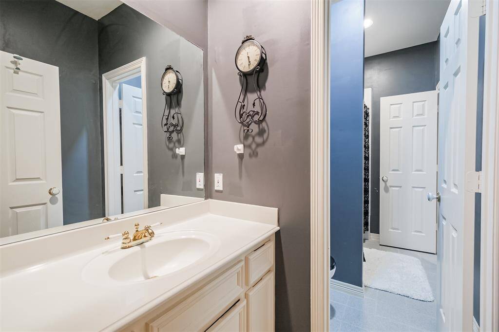 VERSATILE GUEST BEDROOM BOASTING WALL-SIZED BUILT-IN SHELVES, MAKING IT PERFECT FOR A HOME LIBRARY, OFFICE, OR STORAGE.
