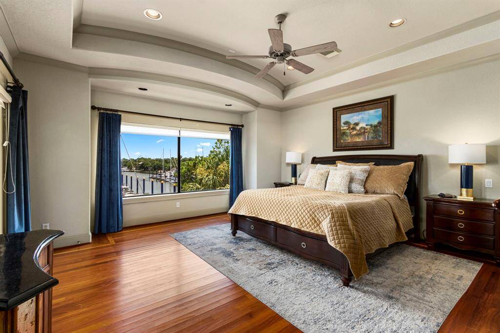 The Primary Retreat offers Amazing Marina Waterfront Views and Warm Wood Flooring w/ Custom Border Insets.