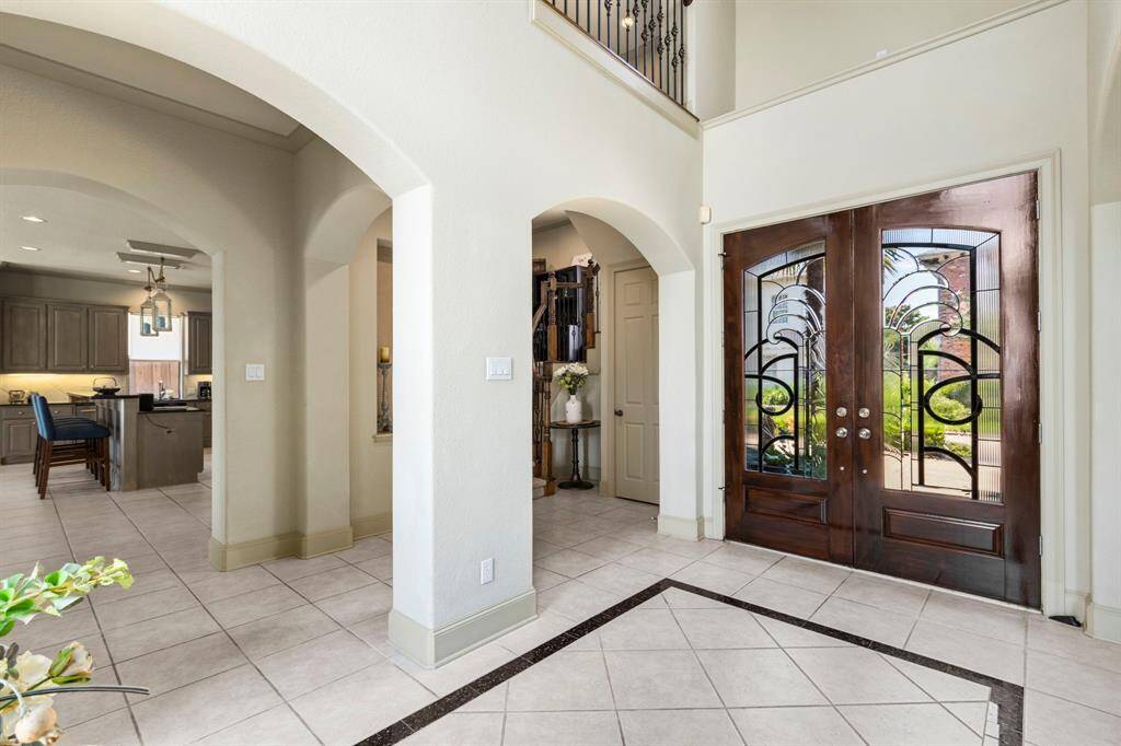 Double Custom Glass Doors with Custom Tile Inset Features in the Entry Area.