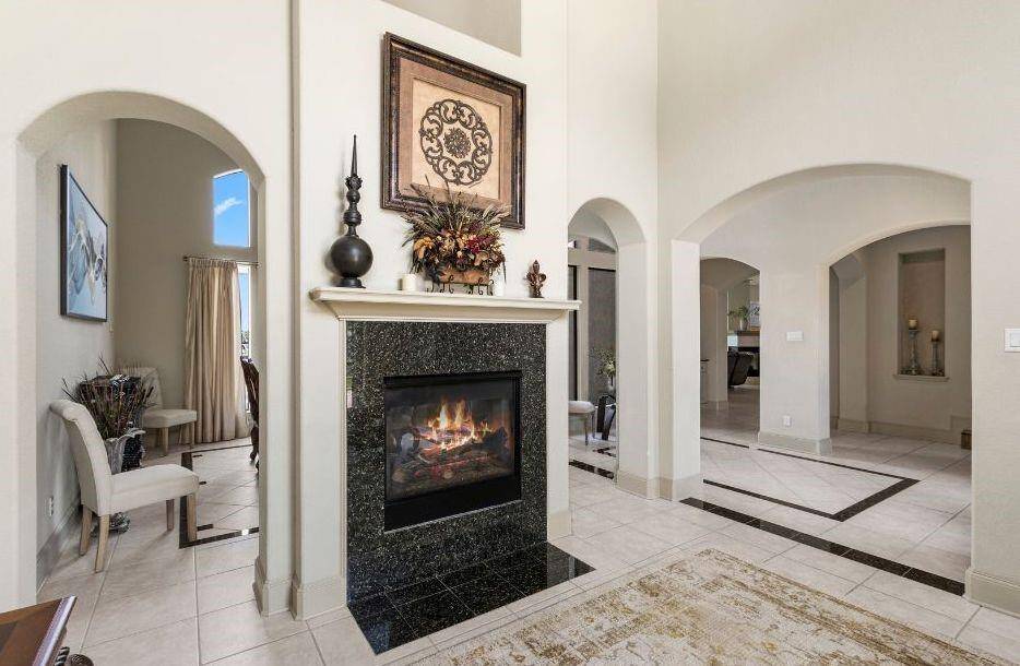 A Dual Sided Cozy Fireplace is the Centerpiece of the Formal Living and Dining Areas.