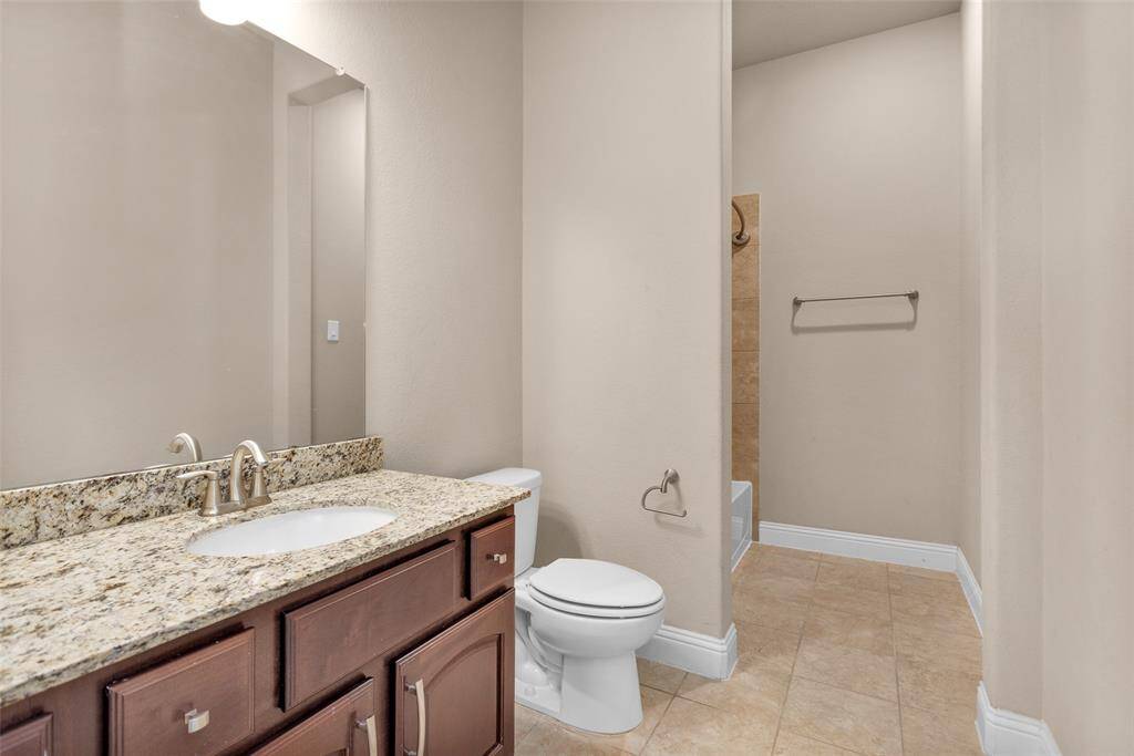 Another secondary bathroom featuring granite countertops, undermount sink, modern fixtures and neutral color palette