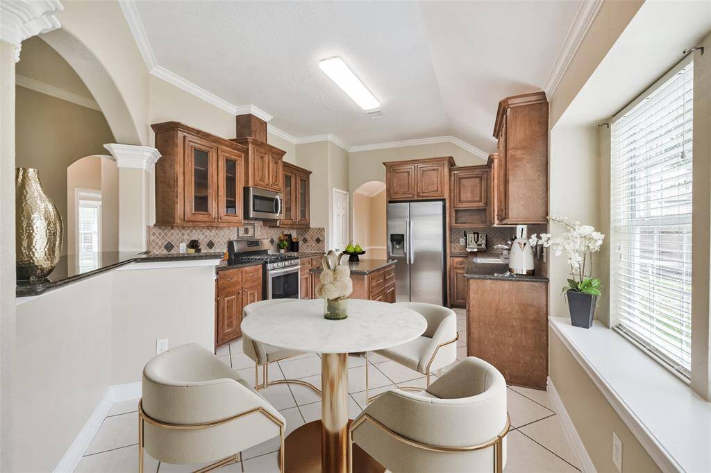 Chef's eat-in island kitchen features 42" solid wood custom cabinets with crown molding, stainless steel appliances, lengthy granite countertops and a breakfast bar