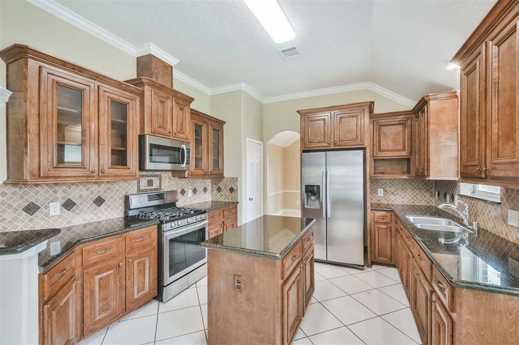 Chef's eat-in island kitchen features 42" solid wood custom cabinets with crown molding, stainless steel appliances, lengthy granite countertops and a breakfast bar