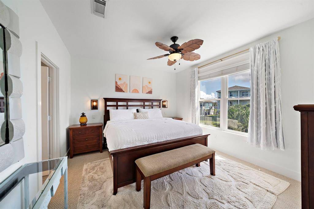 Welcome to the primary suite with views of the beach and pond with fountain.