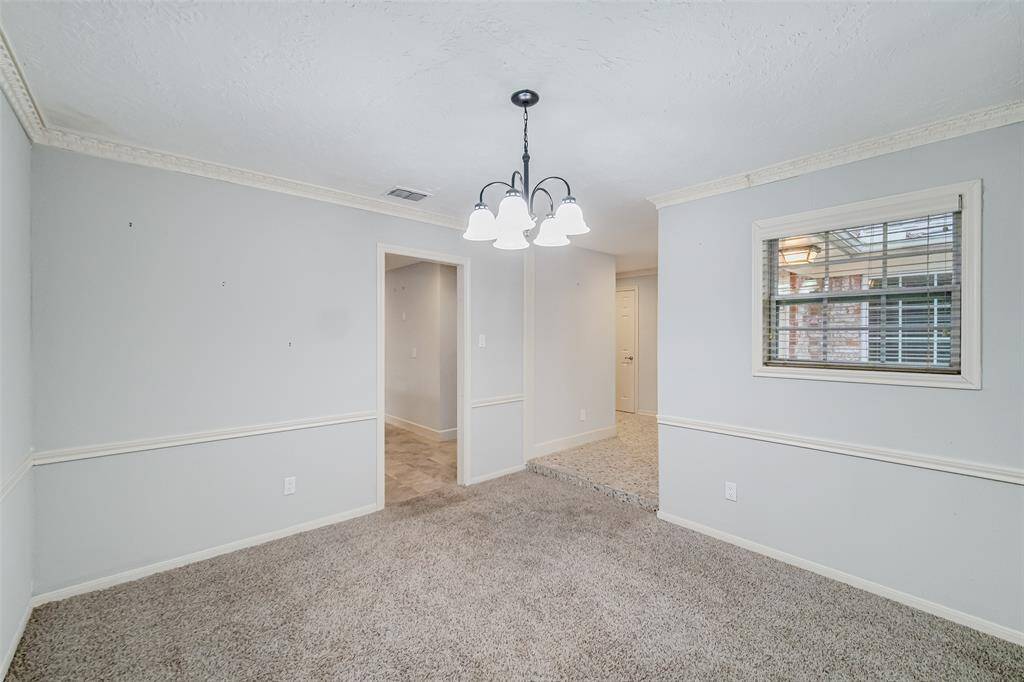 Easy access to the kitchen with a pass through!  Crown molding and chair rail makes the space feel more welcoming as it draws you into the house!