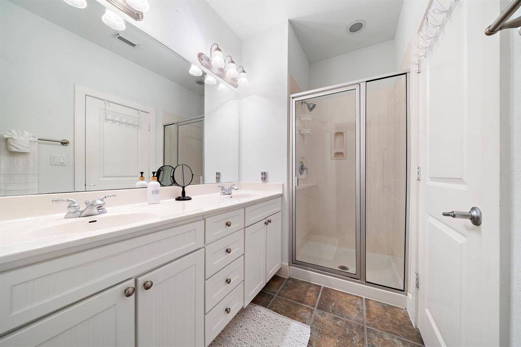 Private primary bathroom with shower, double vanities, and separate water closet.