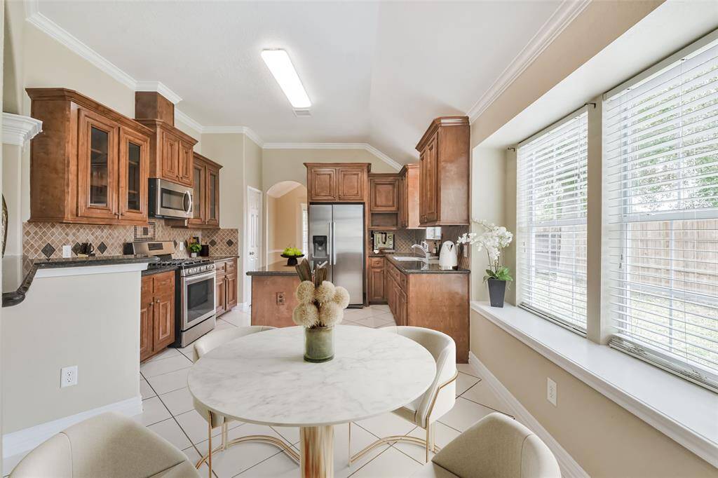 Chef's eat-in island kitchen features 42" solid wood custom cabinets with crown molding, stainless steel appliances, lengthy granite countertops and a breakfast bar