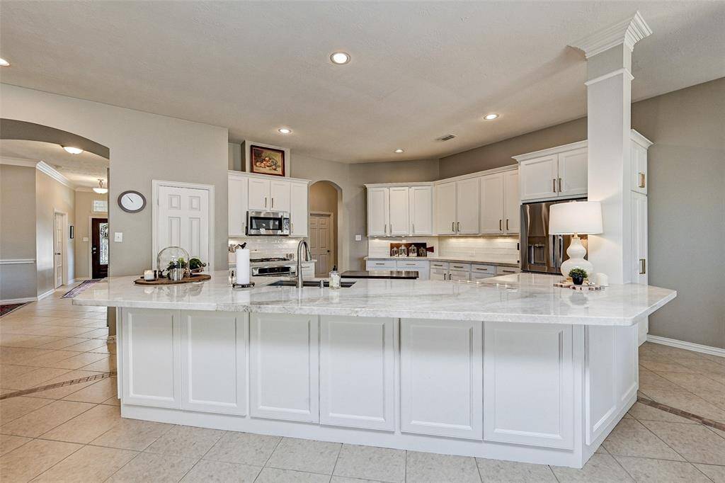 This spacious kitchen features a large, elegant breakfast bar with a Quartz countertop and storage space underneath.  Space is perfect for cooking and entertaining.
