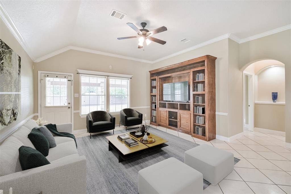 Living room features high ceilings and custom built-in cabinetry