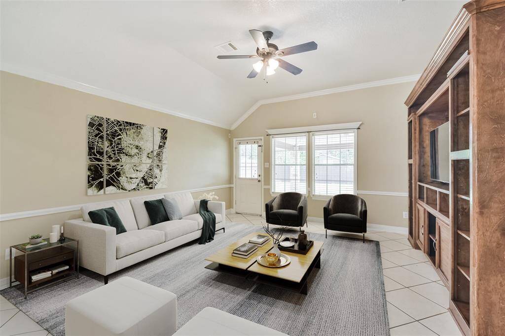 Living room features high ceilings and custom built-in cabinetry