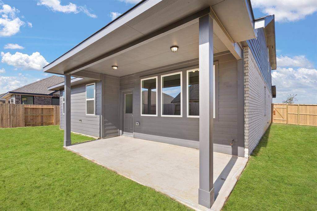 The covered patio is generously sized, providing ample space for various outdoor activities.
