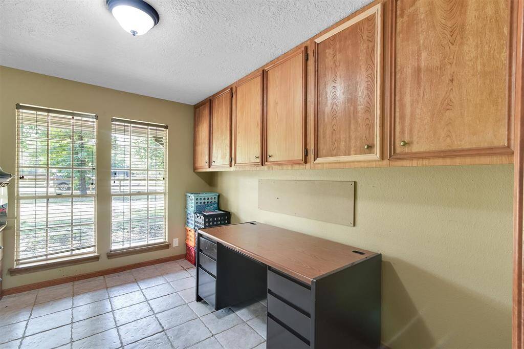 Study/office with built in cabinets and great view to the front yard