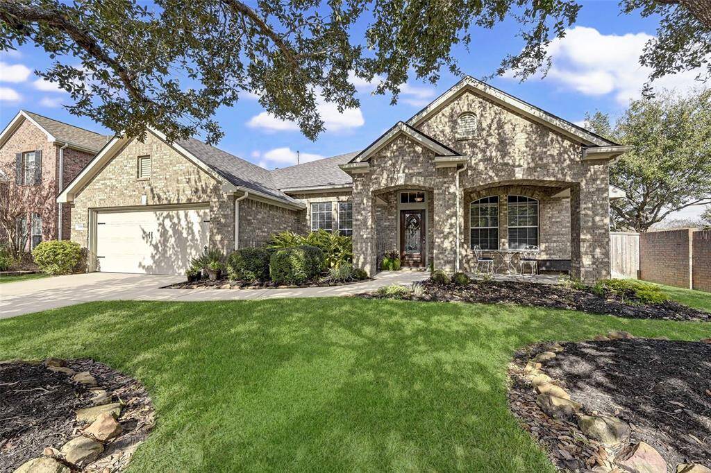 This charming home features a classic brick facade with a welcoming front porch and well-maintained landscaping. The lush green lawn add to its curb appeal.