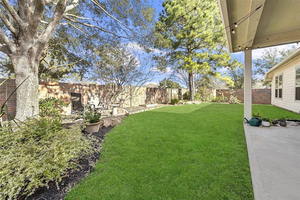 The yard is enclosed by a brick fence, offering privacy.