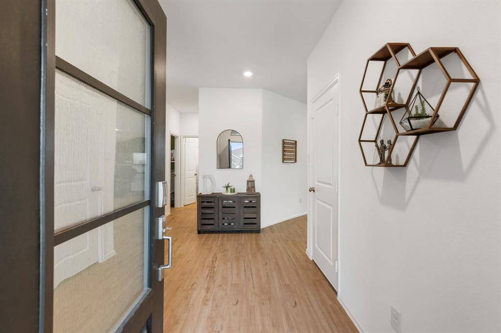 This home has a modern black front door with frosted glass and opens up to the inviting and bright entryway.