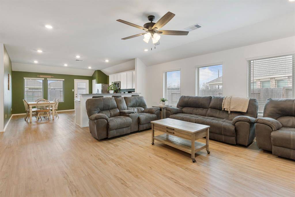 This open concept living space has vinyl flooring, recessed lighting, and is connected to the kitchen making this every entertainers dream!