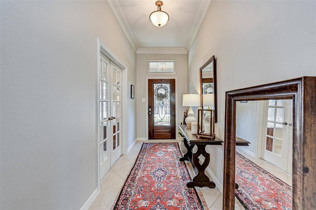A welcoming entryway with a decorative glass front door and neutral walls.