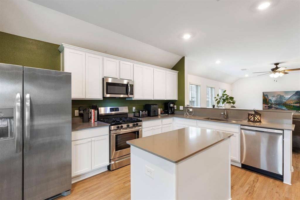 The kitchen is complete with stainless steel appliances and quartz countertops.