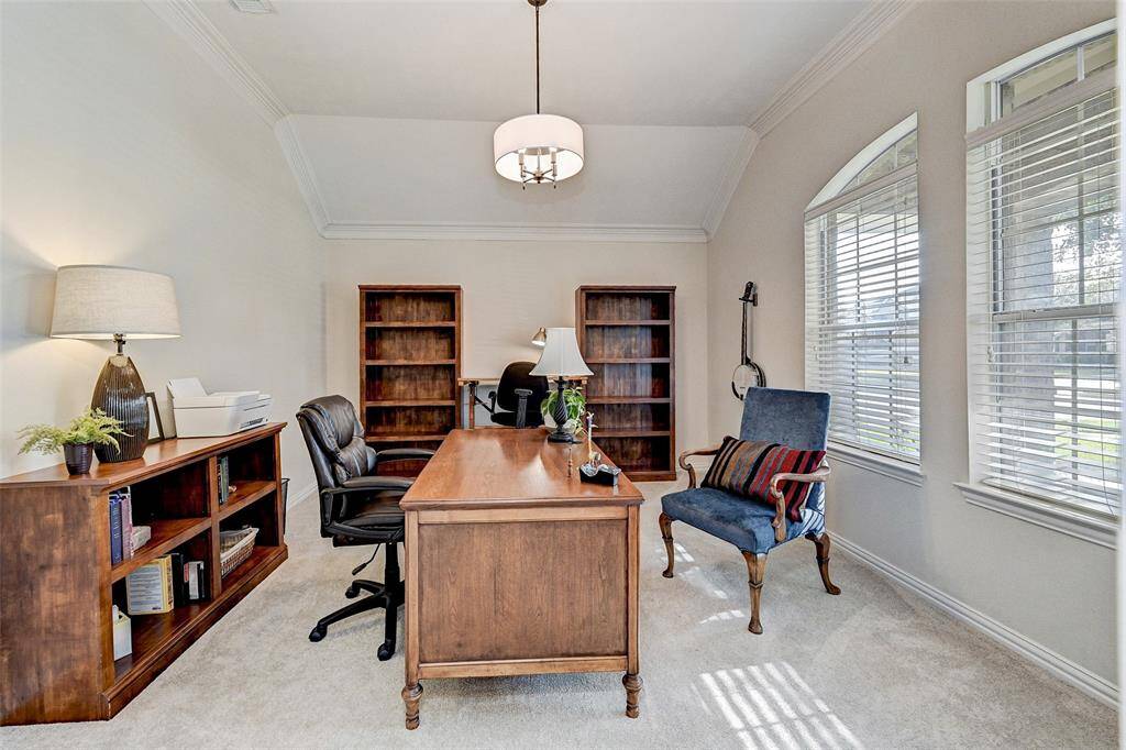 Study has cheerful, natural lighting, plush carpet and updated light fixture.