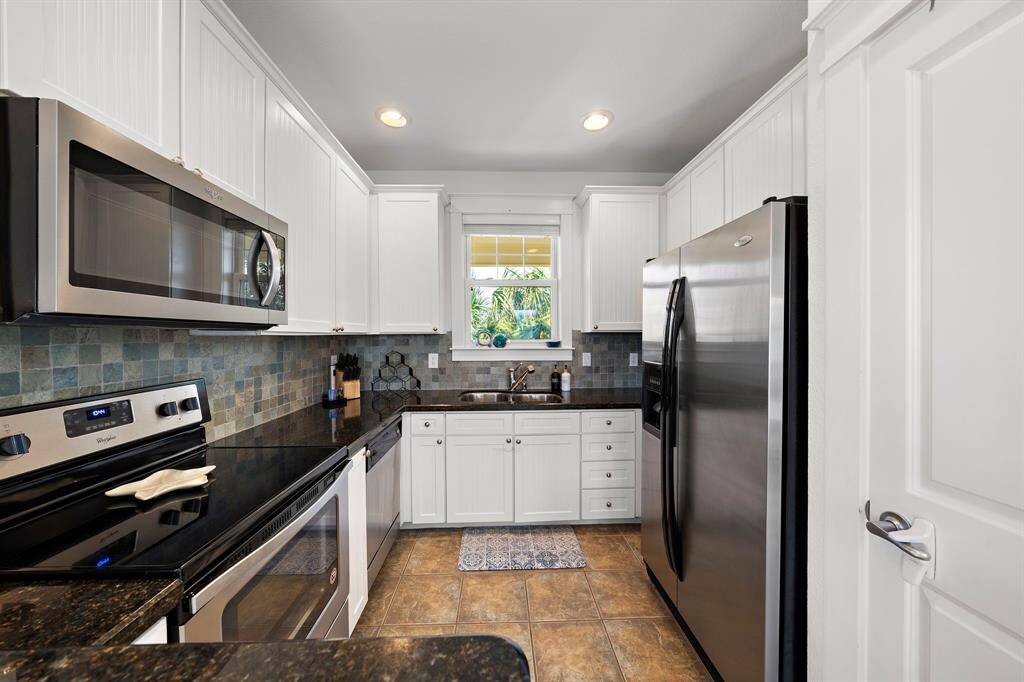 Well equipped kitchen with granite counters and pantry to the right.  All appliances remain, including refrigerator and washer and dryer.