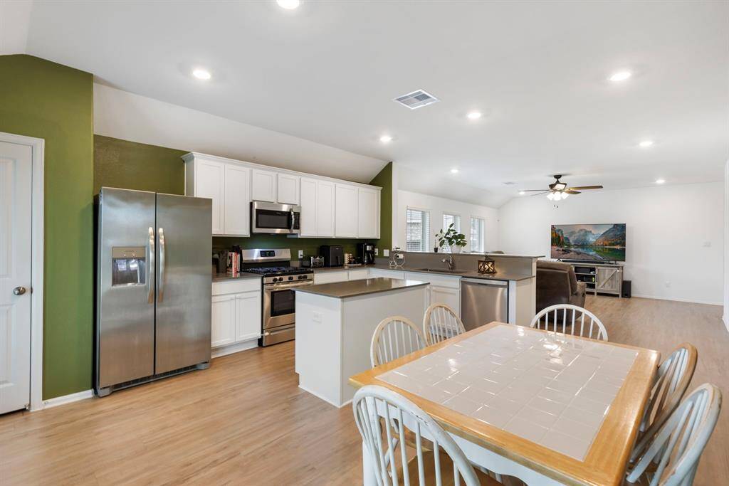This kitchen comes with ample cabinet space, a central island, and leads to your back patio.