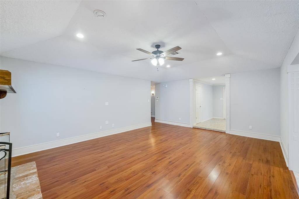 This view is from the family room and looks back through the entry into the hallway, with the bedrooms on the left! The room has recessed lighting and a ceiling fan.