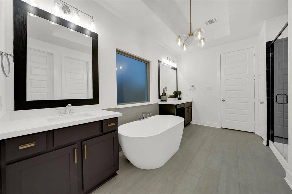 The chandelier is such a classy added touch to this already sophisticated bathroom.