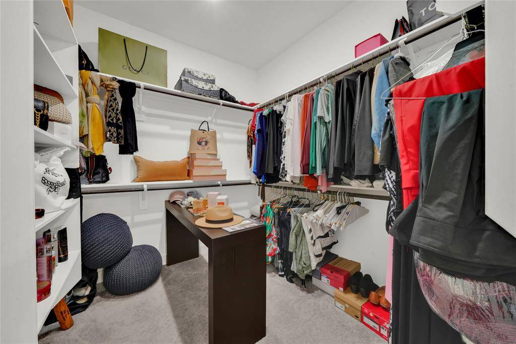 The second primary closet with plenty of shelving and hanging rods for all your belongings