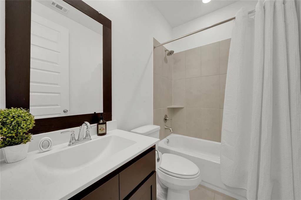 Full guest bath downstairs with framed mirror