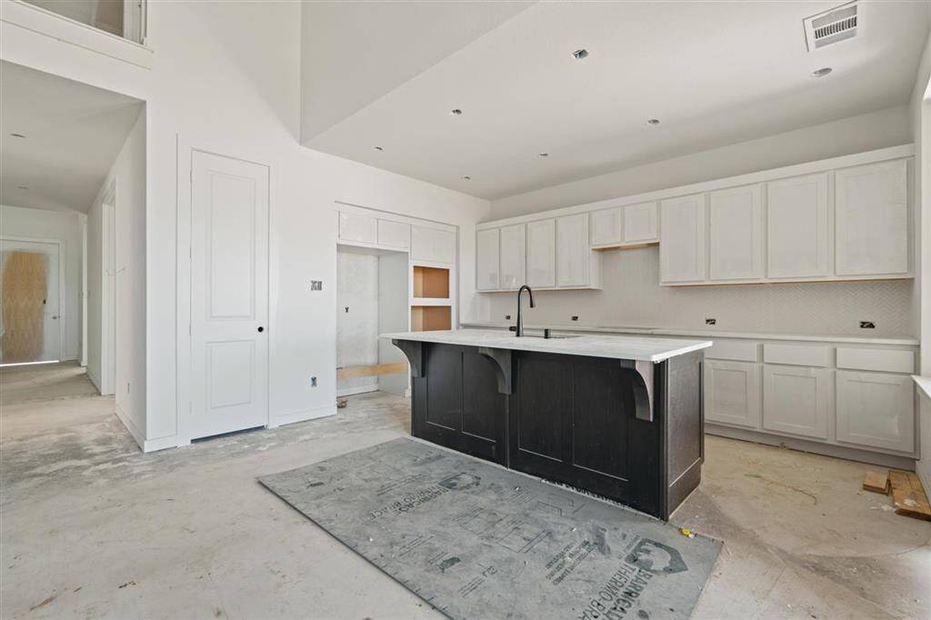 Kitchen island features generous countertop space and doubles as casual dining area.